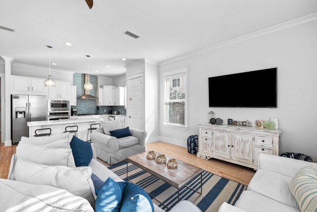 living room featuring ornamental molding and light hardwood / wood-style floors