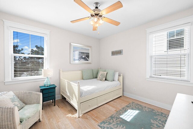 bedroom featuring light hardwood / wood-style floors, multiple windows, and ceiling fan