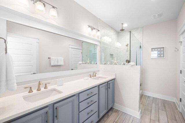 bathroom featuring wood-type flooring, vanity, and a shower with shower door