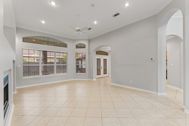 unfurnished living room with ceiling fan, light tile patterned floors, and ornamental molding