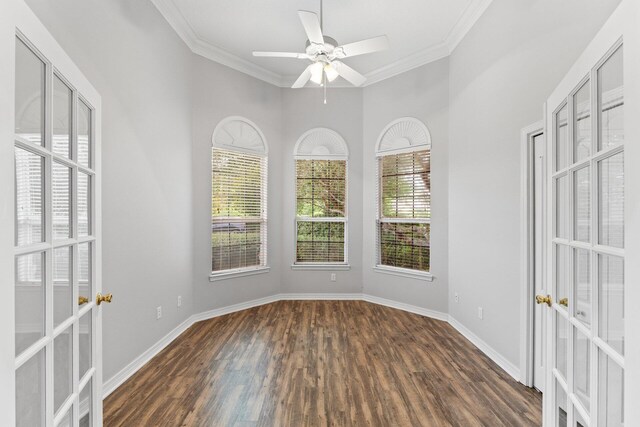 empty room with ceiling fan, dark hardwood / wood-style flooring, and ornamental molding