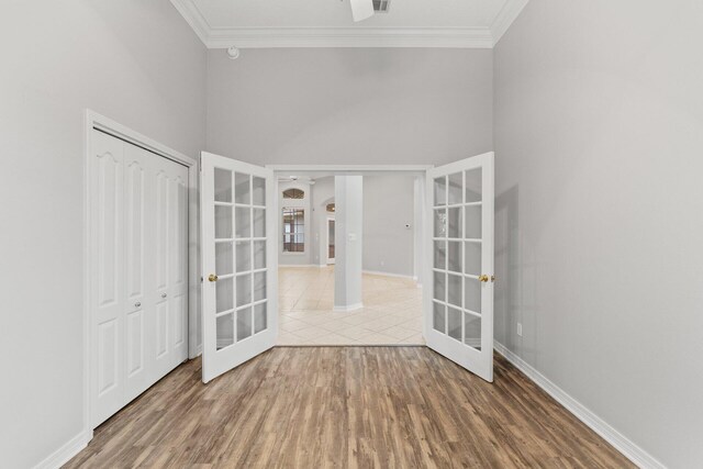 foyer entrance featuring wood-type flooring, decorative columns, crown molding, and french doors