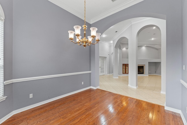 unfurnished dining area featuring crown molding, a notable chandelier, and hardwood / wood-style floors