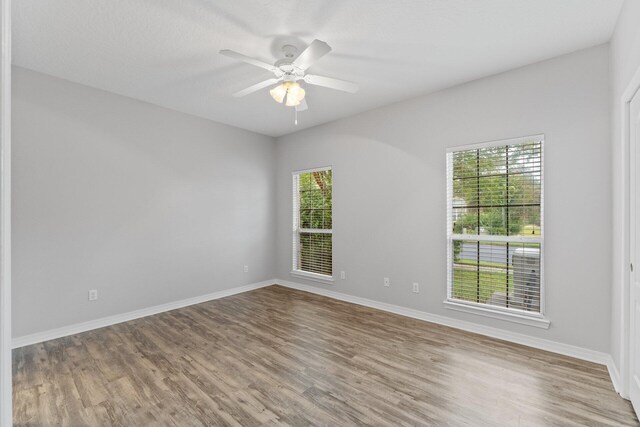 unfurnished room with ceiling fan and hardwood / wood-style flooring