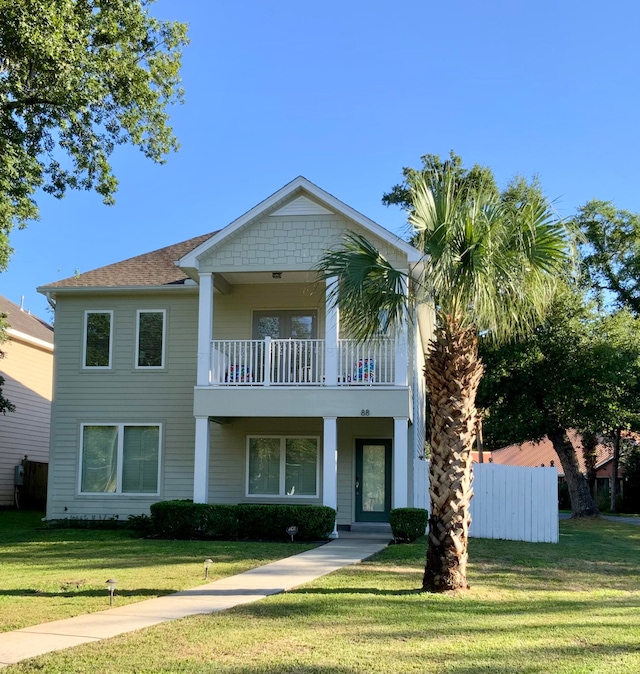 view of front facade with a front yard and a balcony