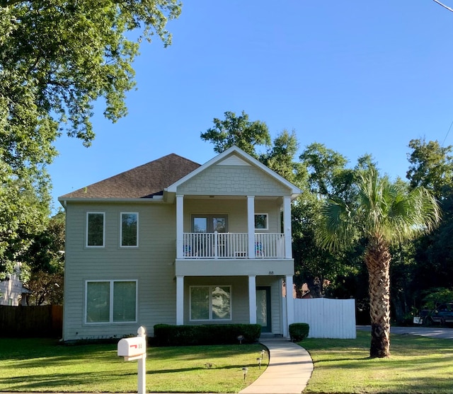 view of front facade featuring a front lawn and a balcony