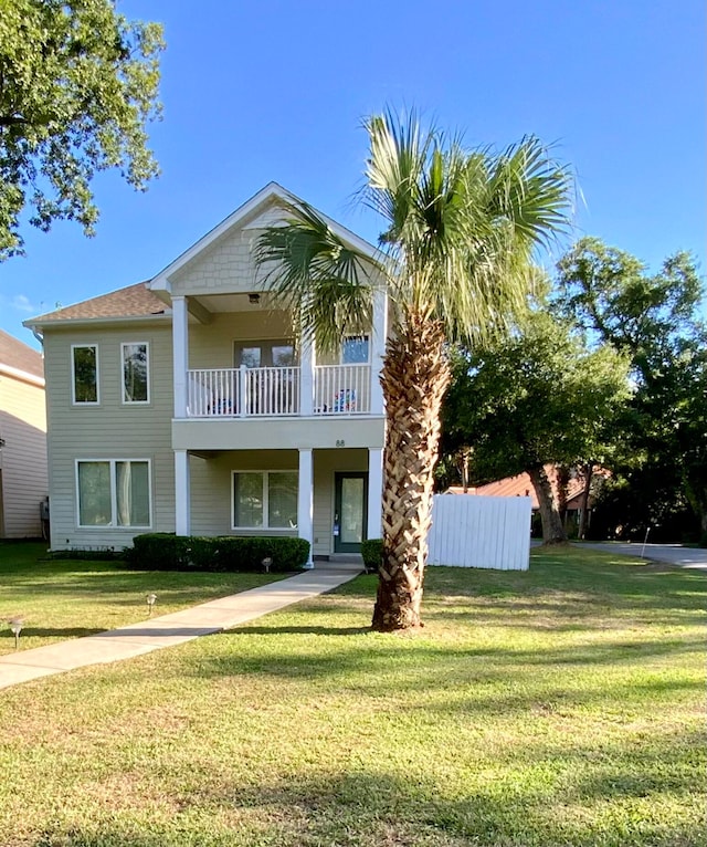 view of front of house with a front lawn and a balcony