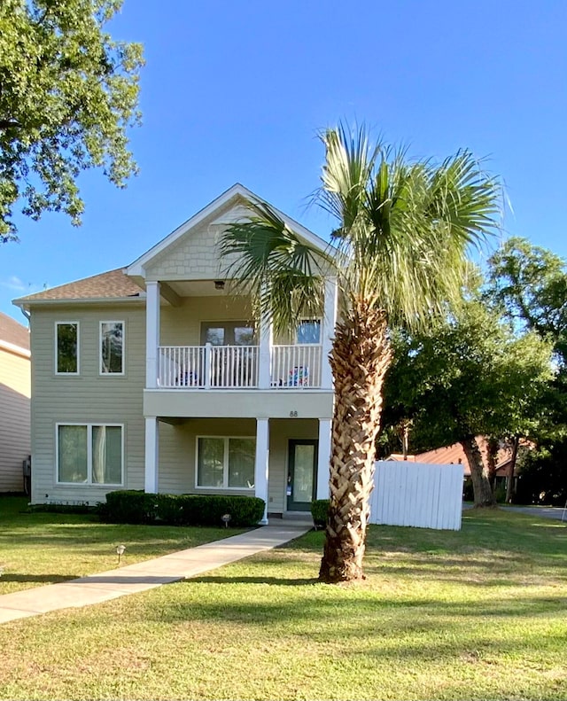 view of front of house featuring a balcony and a front yard