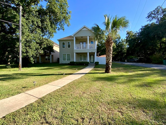 view of front of house featuring a balcony and a front yard