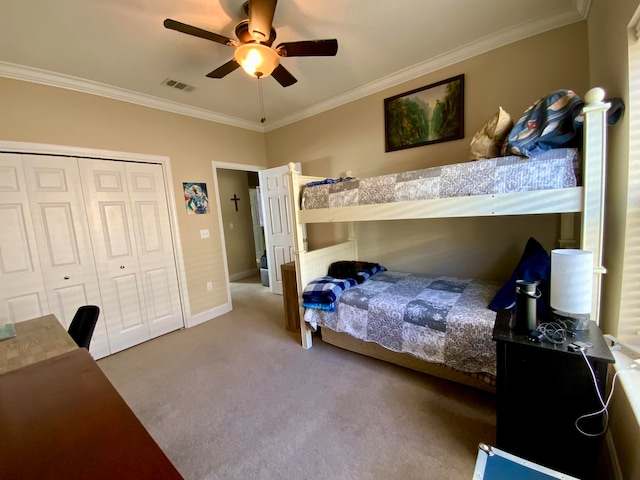 carpeted bedroom featuring ceiling fan, crown molding, and a closet