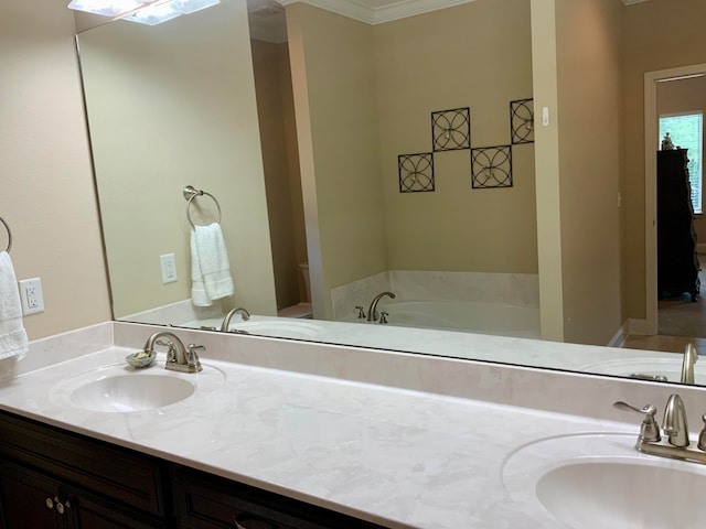 bathroom with vanity, crown molding, and a washtub