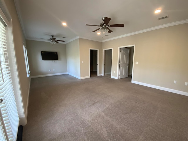 spare room featuring dark colored carpet, ceiling fan, and crown molding