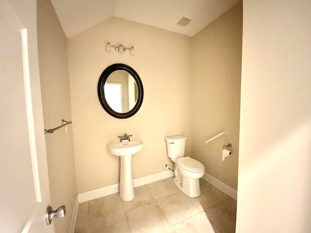 bathroom with tile patterned floors, toilet, vaulted ceiling, and sink