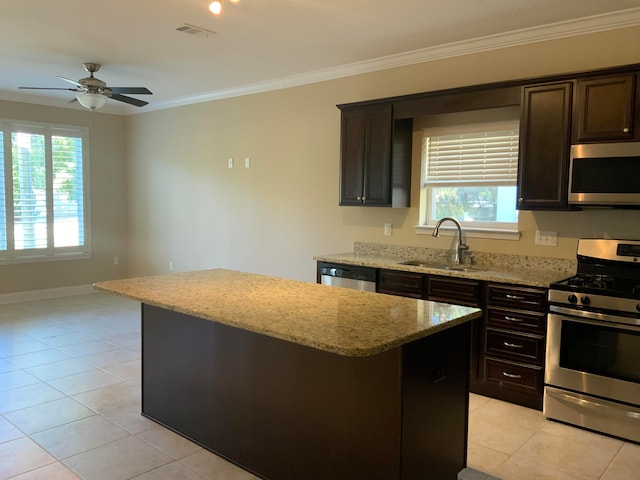 kitchen with stainless steel appliances, a wealth of natural light, sink, and a kitchen island