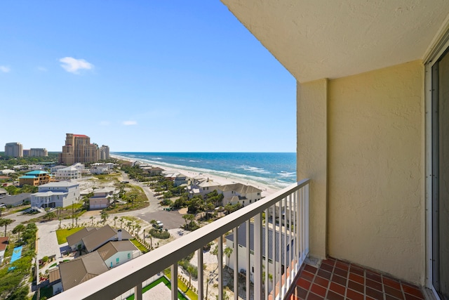 balcony with a water view and a view of the beach