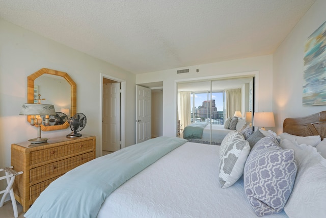 bedroom with a textured ceiling and access to exterior