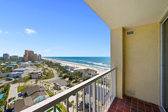 balcony with a water view and a view of the beach