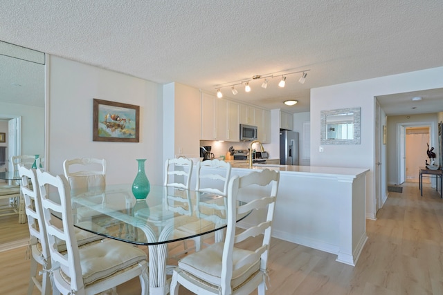 dining area featuring light hardwood / wood-style floors and a textured ceiling