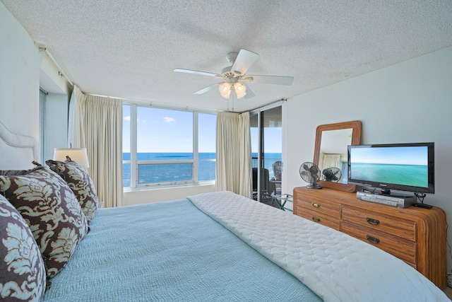 bedroom featuring a wall of windows, a textured ceiling, and ceiling fan