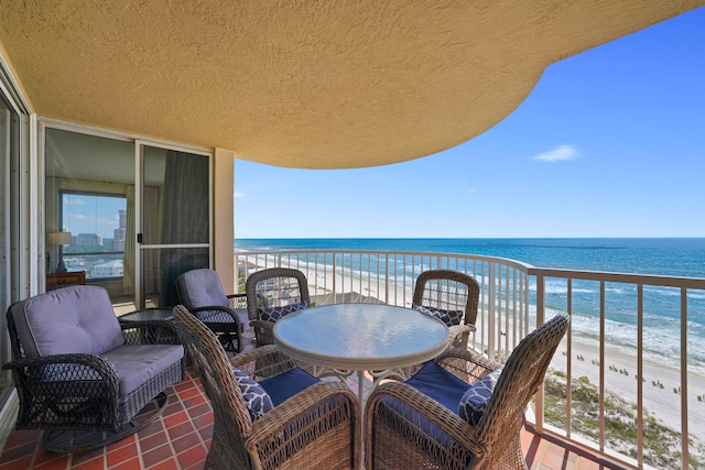 balcony with a water view and a view of the beach