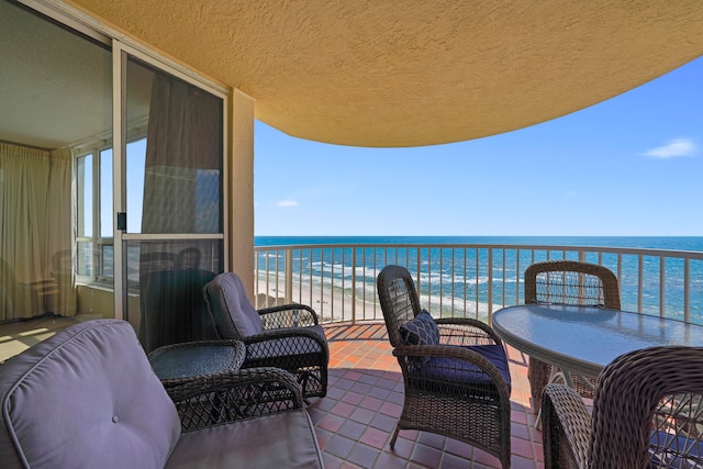 balcony with a water view and a beach view