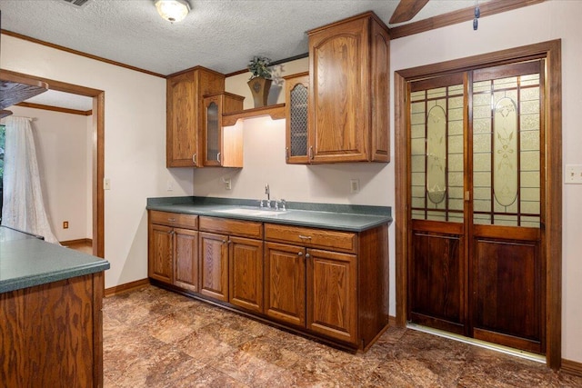 kitchen featuring crown molding, a textured ceiling, and sink