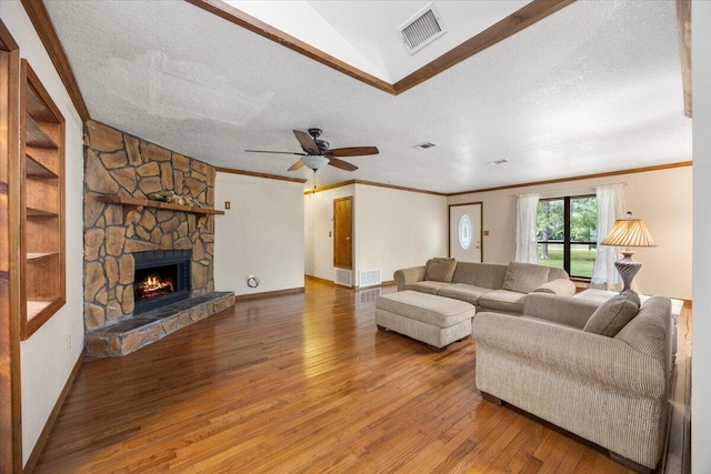 living room featuring a textured ceiling, wood-type flooring, and a fireplace