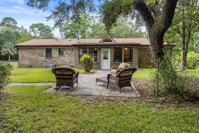 rear view of house with central AC, a yard, and a patio area