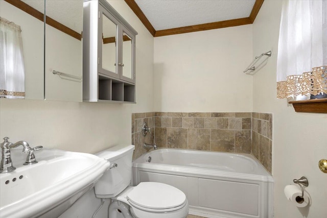 bathroom featuring a textured ceiling, a tub, toilet, and sink