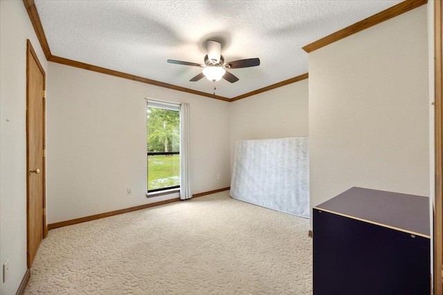 carpeted spare room featuring a textured ceiling, ceiling fan, and ornamental molding