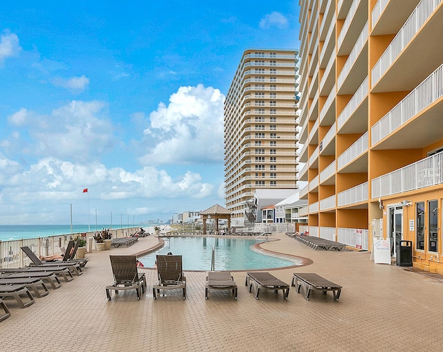 view of swimming pool with a water view and a patio