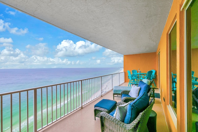 balcony with a water view and a beach view