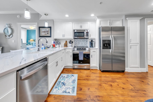 kitchen featuring appliances with stainless steel finishes, white cabinetry, and light hardwood / wood-style floors