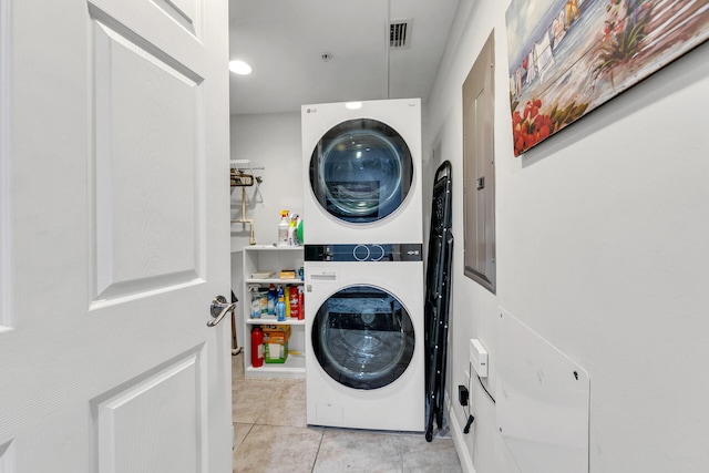 washroom featuring light tile patterned floors and stacked washer and dryer