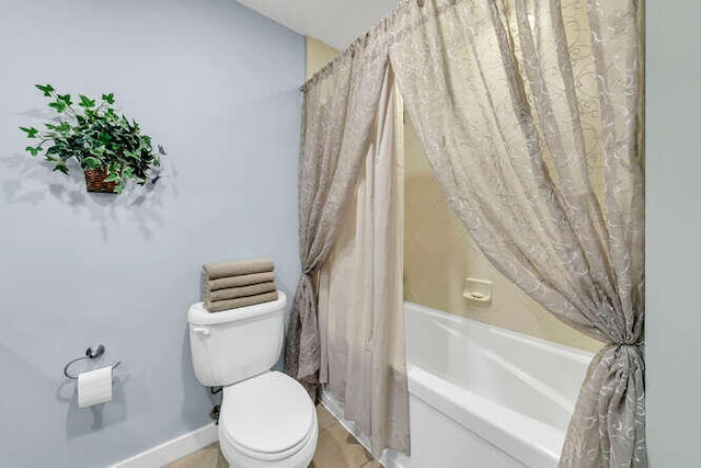 bathroom featuring shower / tub combo and toilet