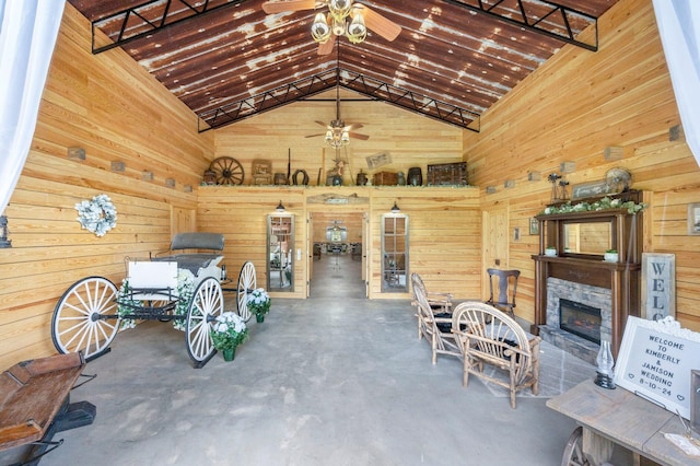 interior space featuring ceiling fan and wooden walls