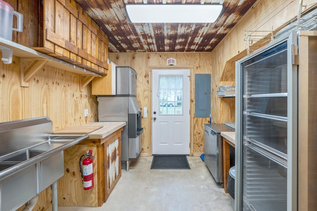 kitchen featuring wood walls, electric panel, and sink