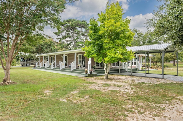 rear view of property featuring a lawn and covered porch