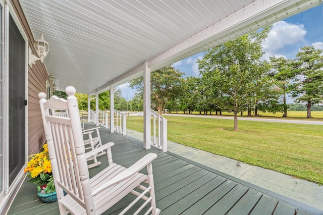 wooden deck featuring a lawn