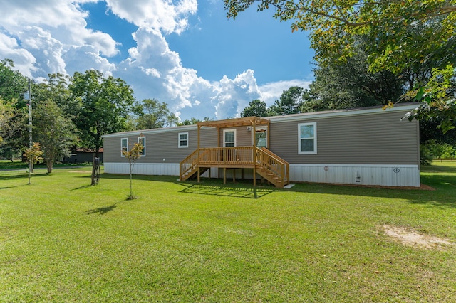 rear view of house with a yard and a wooden deck