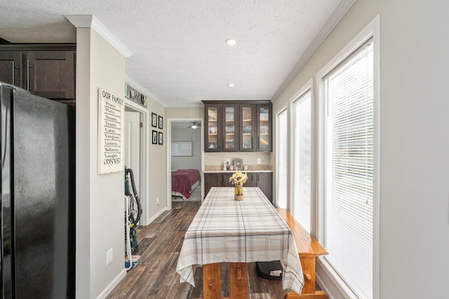 dining space featuring ornamental molding, a textured ceiling, and dark hardwood / wood-style floors