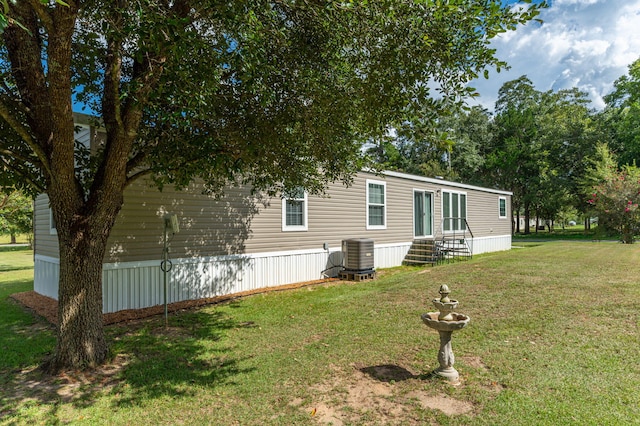 exterior space featuring a front lawn and central AC unit