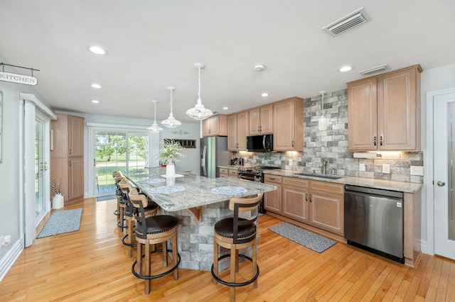 kitchen featuring black appliances, light wood-type flooring, and a kitchen island