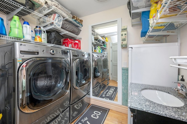 washroom featuring separate washer and dryer, hardwood / wood-style flooring, and sink