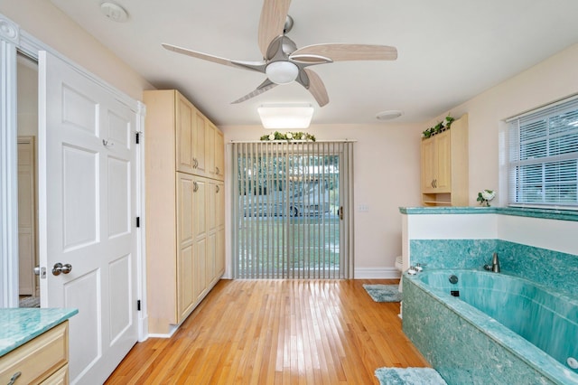 bathroom featuring toilet, a bathing tub, vanity, ceiling fan, and hardwood / wood-style flooring