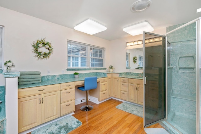 bathroom featuring hardwood / wood-style floors, walk in shower, and vanity