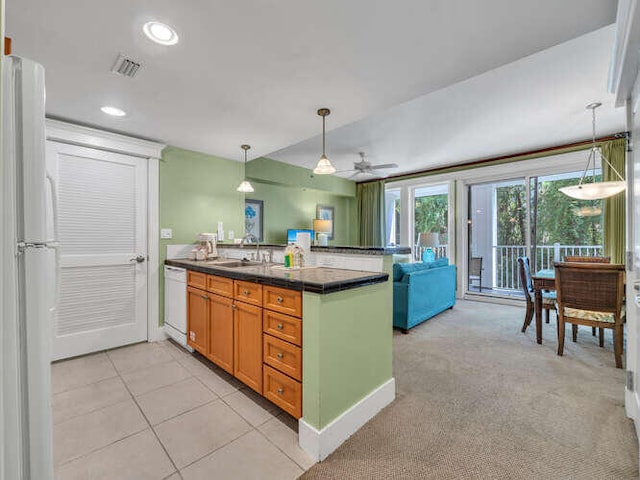 kitchen featuring hanging light fixtures, white appliances, kitchen peninsula, sink, and light colored carpet