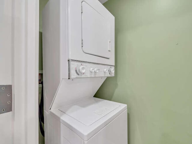 washroom featuring stacked washing maching and dryer