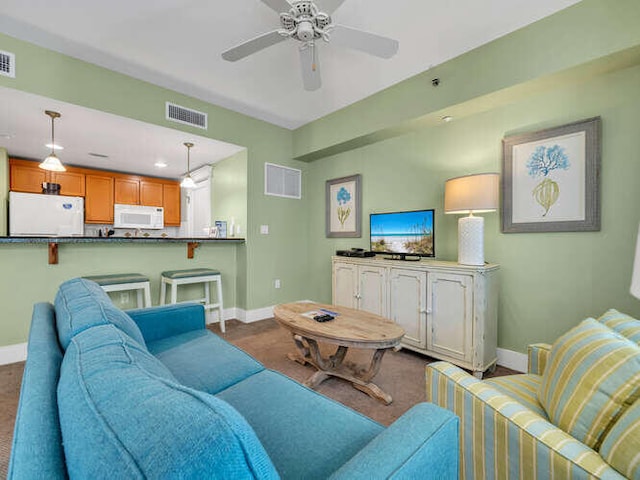 carpeted living room with ceiling fan