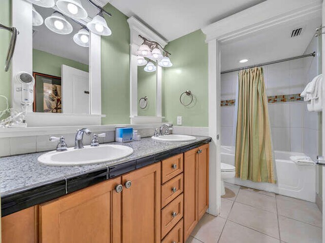 full bathroom with tile patterned flooring, shower / bath combo, vanity, and toilet